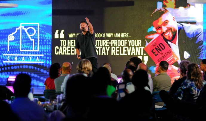 Speaker presents book to audience on stage